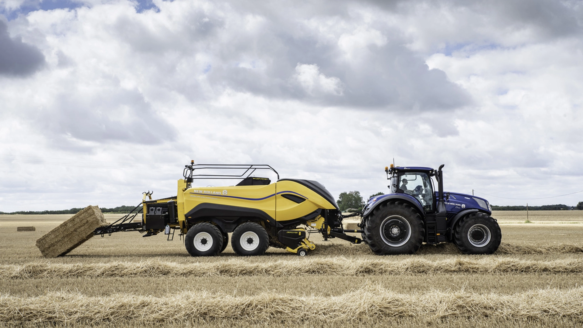 fenoeforragem-new-holland-modelo-big-baler-alta-densidade-em-campo-visao-totalmente-lateral-puxando-feno